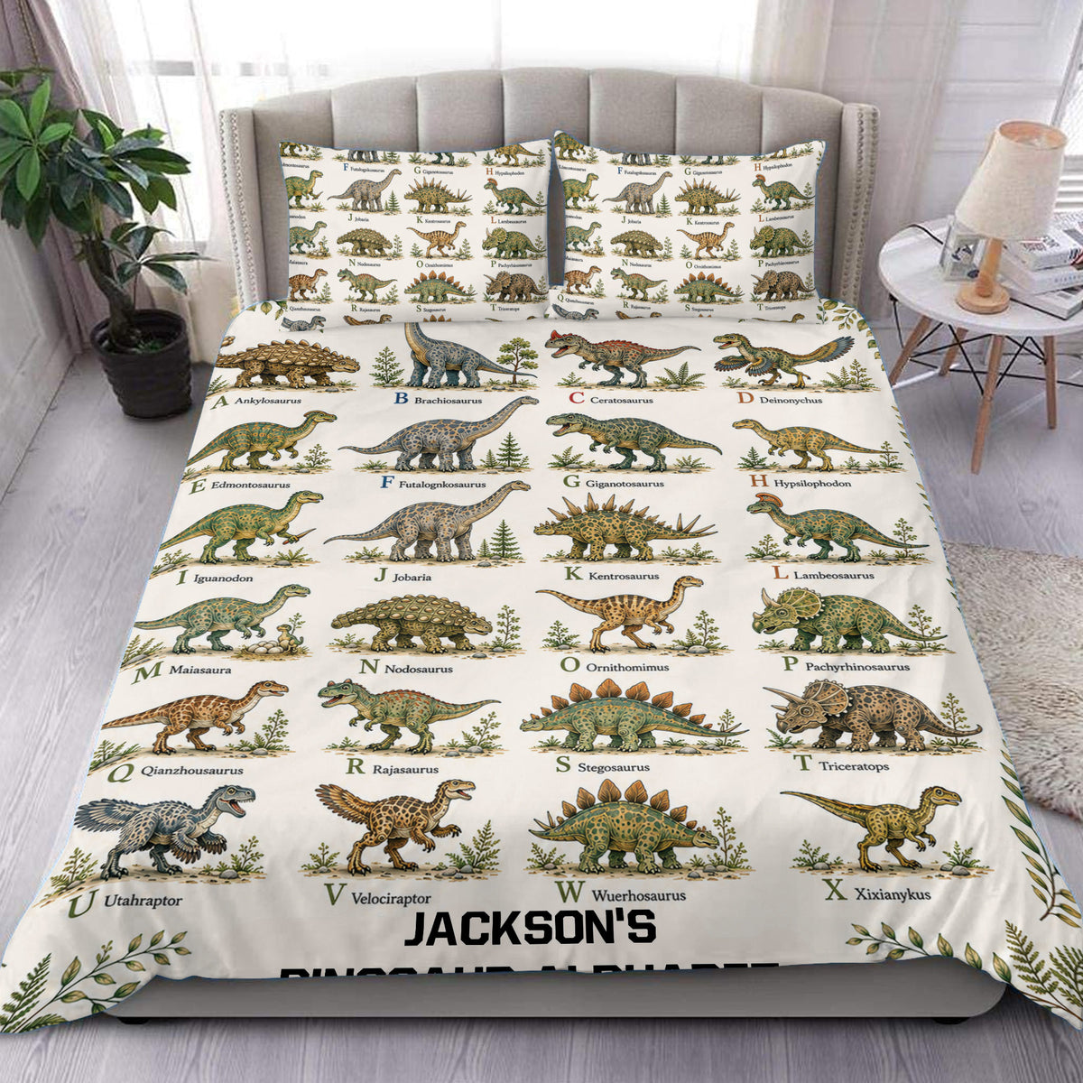 Dinosaur alphabet duvet cover set displayed on a bed with illustrated prehistoric animals and leafy accents
