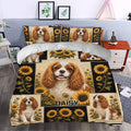 Cavalier King Charles duvet cover set styled on a bedroom bed with black and gold sunflower artwork