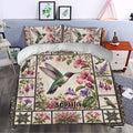 Hummingbird bedding set styled in a bedroom with pink hibiscus, purple flowers, and botanical artwork