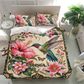 Tropical hummingbird bedding set presented in a bright bedroom with floral artwork and matching printed pillowcases