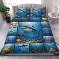 Shark duvet cover set displayed on a bed with blue underwater scenes, coral reefs, shells, and custom lettering