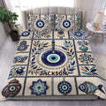 Evil eye duvet cover set displayed on a bed with blue and turquoise motifs, ornate borders, and botanical accents