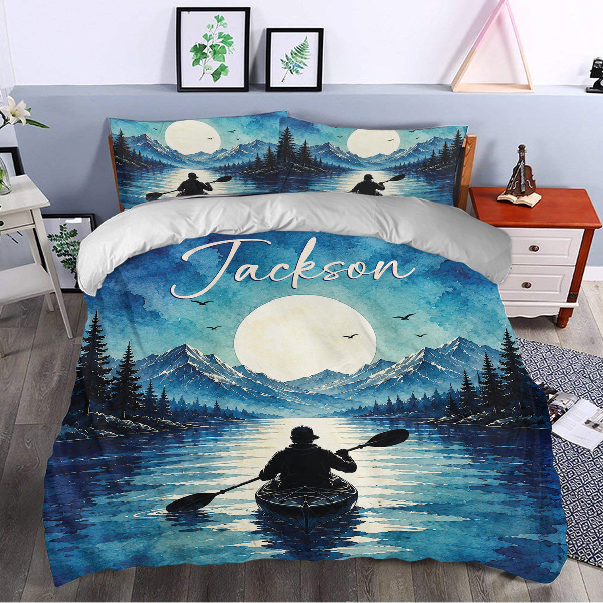 Blue kayak duvet cover displayed in a bedroom with moonlit mountains, evergreen trees, and lake artwork