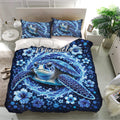 Blue sea turtle bedding set presented in a bright bedroom with ocean waves, flowers, and tropical decor