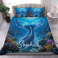 Mermaid duvet cover set displayed on a bed with a glowing blue underwater scene and colorful coral reef