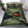 Ladybug duvet cover set displayed on a bed with red ladybugs, green leaves, and dark botanical accents