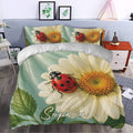 Ladybug duvet cover set styled in a bedroom with large daisies, green foliage, and sage botanical tones