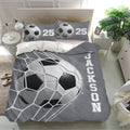 Soccer bedding set shown in a bright bedroom with matching pillows and oversized grayscale ball artwork