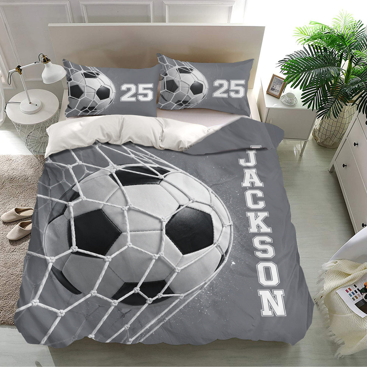 Soccer bedding set shown in a bright bedroom with matching pillows and oversized grayscale ball artwork