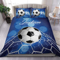 Blue soccer duvet cover set displayed on a bed with soccer balls, goal net artwork, and matching pillows