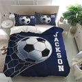 Navy soccer bedding set displayed in a bright bedroom with matching soccer ball pillow designs