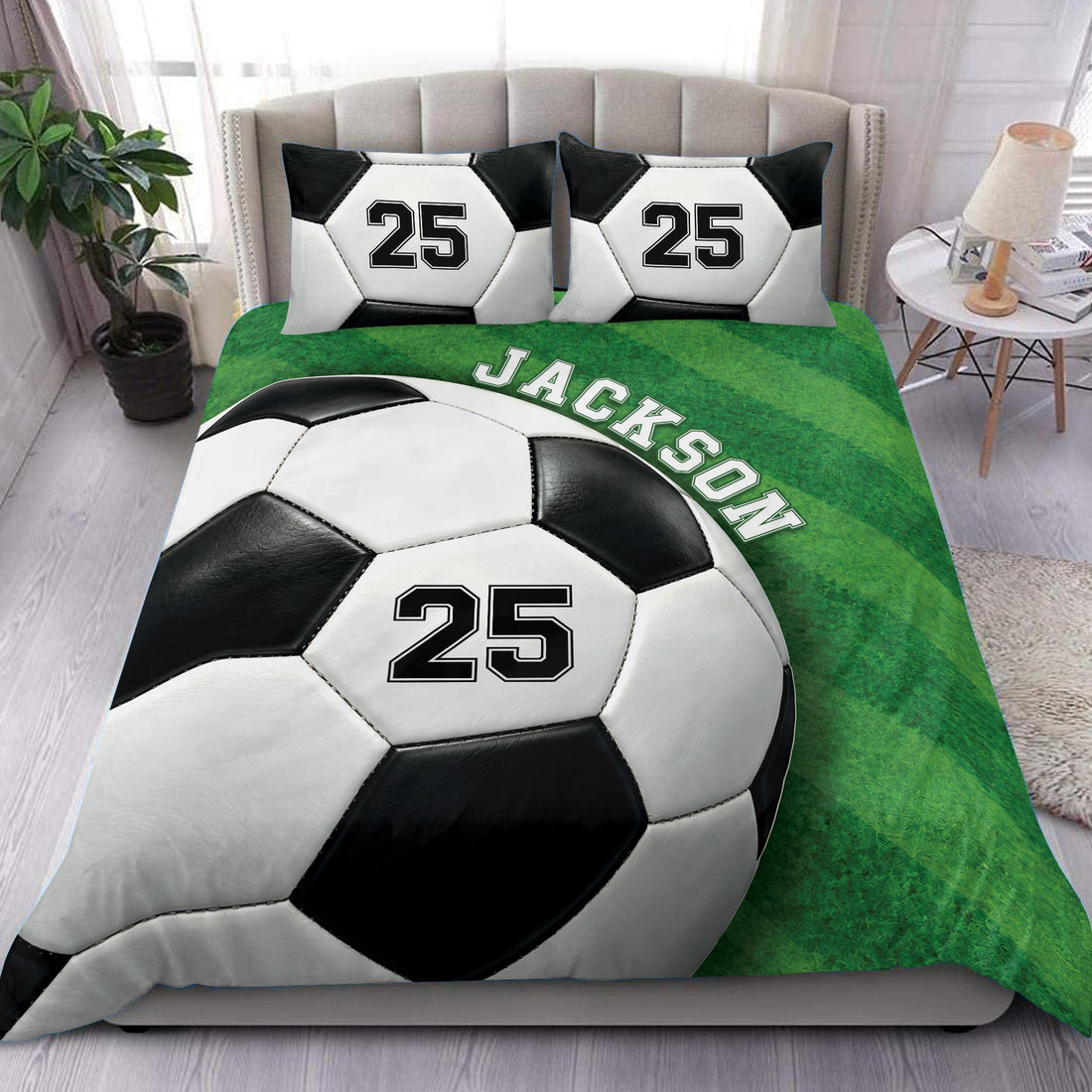 Soccer duvet cover set styled on a bed with bold black and white soccer balls on green field artwork