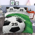 Soccer duvet cover set displayed in a bedroom with green field artwork and bold soccer ball design