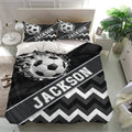 Custom soccer bedding set displayed in a bright bedroom with ball graphics and geometric chevron details