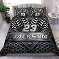Racing duvet cover set displayed on a bed with checkered flags, metallic details, and bold blue accents