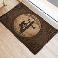 Ornate brown lineman door mat positioned near a bright entry door on light wood flooring