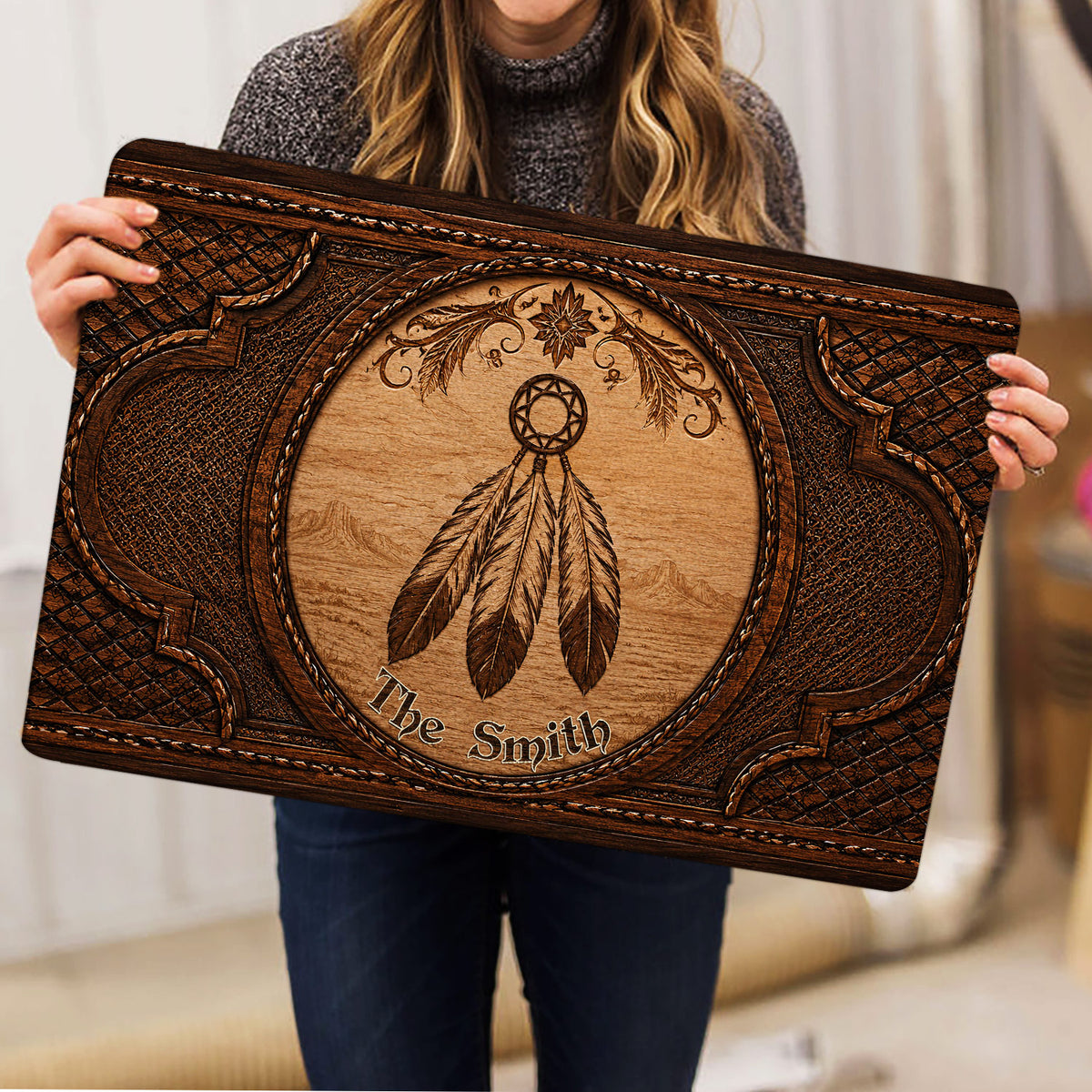 Person holding an ornate American Native dreamcatcher doormat with wood-look artwork