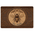 Ornate brown bee doormat with woodgrain artwork, floral scrollwork, and decorative framed border