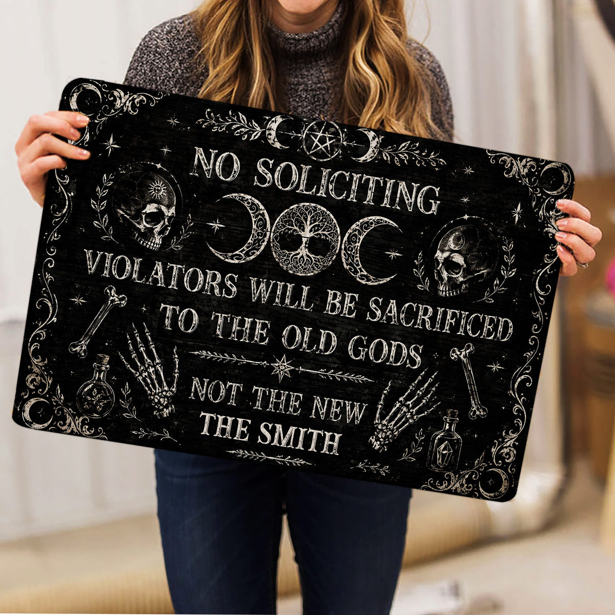 Lifestyle view of a person holding a black Wicca doormat with pentacle and triple moon design