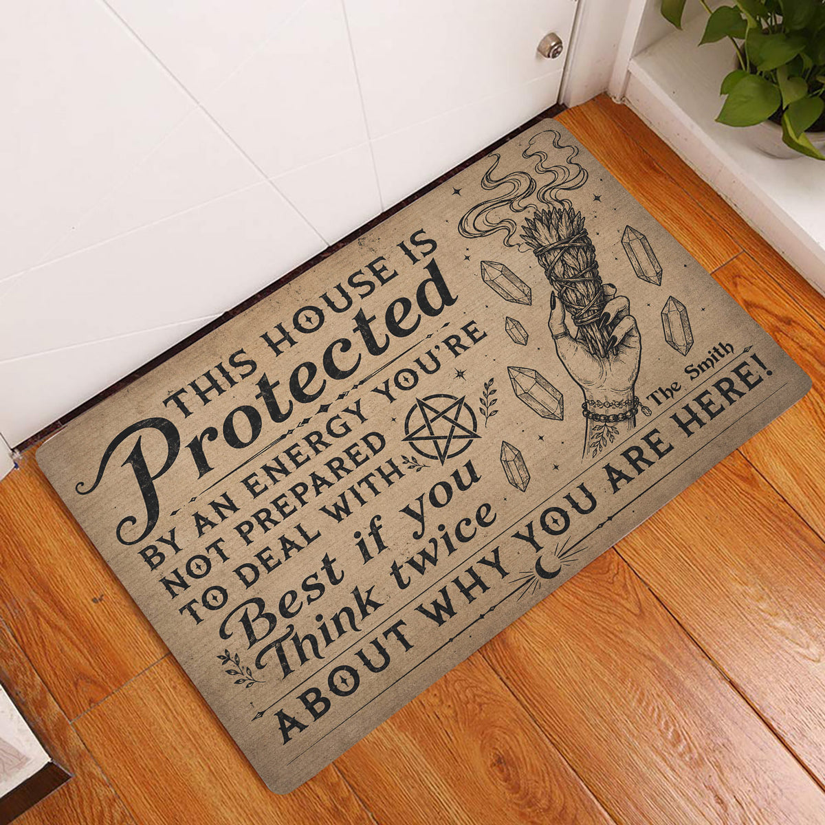 Wicca entryway doormat featuring protective artwork, crystals, pentagram, and cleansing bundle by a door