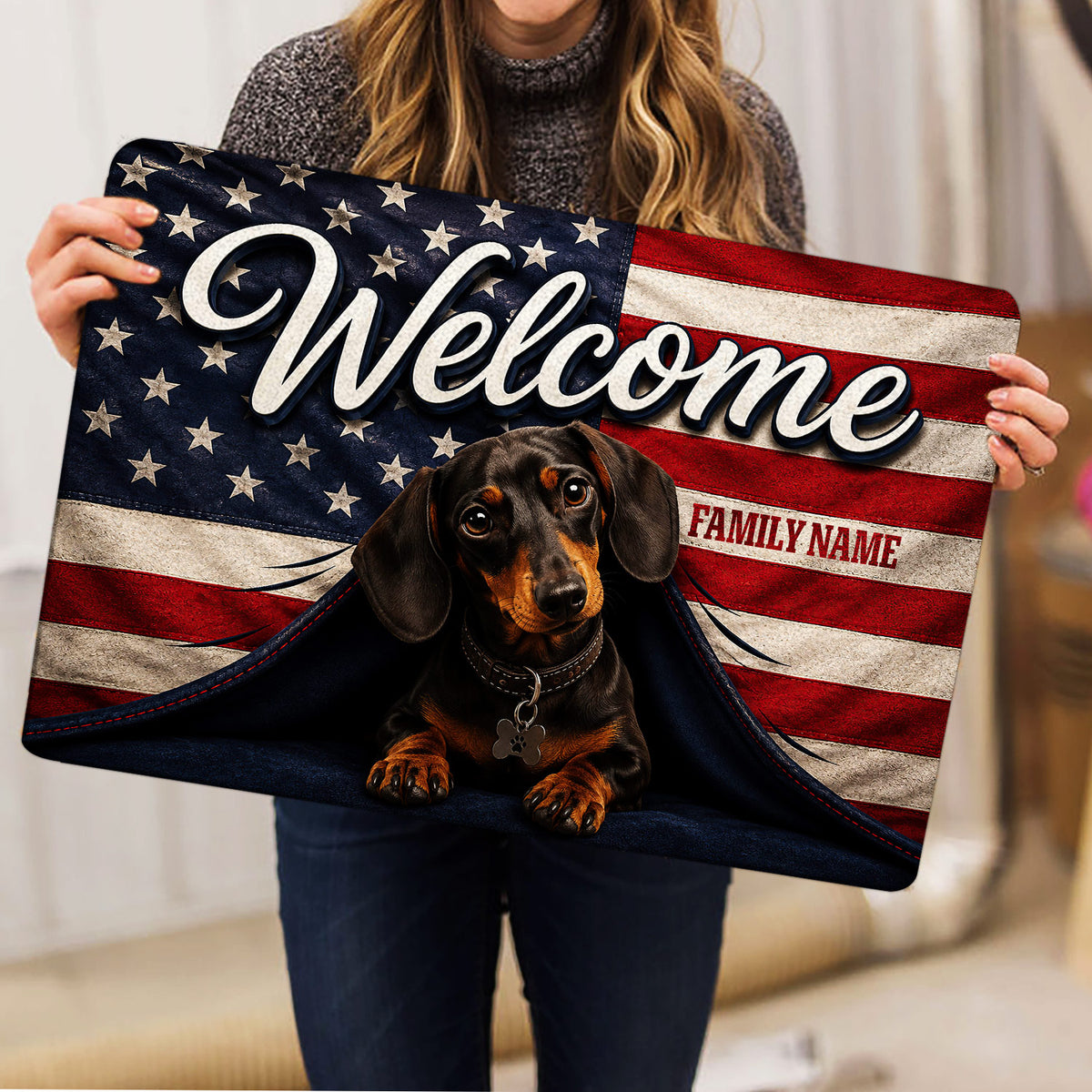 Person holding a patriotic dachshund welcome doormat with stars, stripes and family-themed artwork