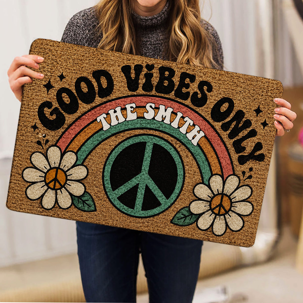 Hippie peace-and-love doormat held indoors, featuring flowers and a rainbow