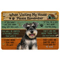 Miniature Schnauzer doormat with rustic wood lettering, paw prints, dog house artwork and humorous welcome message