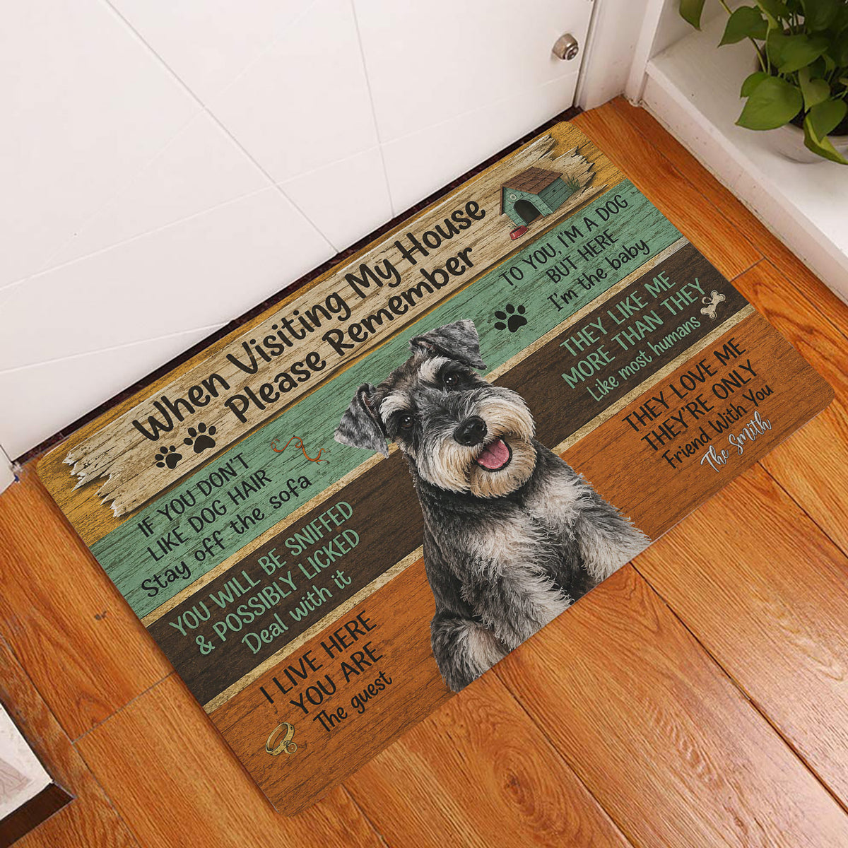Miniature Schnauzer doormat styled at an indoor entryway beside a white door and wood floor