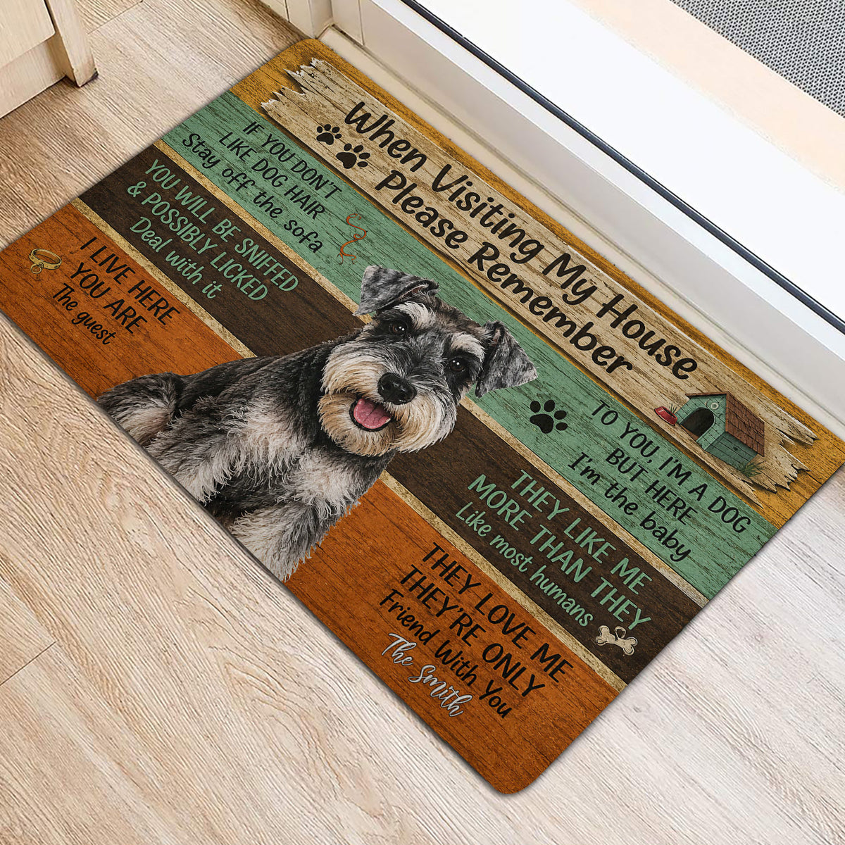 Miniature Schnauzer entryway rug shown near a doorway with rustic wood artwork and playful dog message