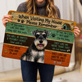 Person holding a rustic Miniature Schnauzer doormat featuring a cheerful dog portrait and paw prints