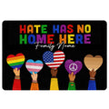 Black LGBT doormat with colorful Pride hearts, inclusive anti-hate message, and hands holding heart designs