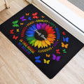 LGBT entryway doormat with a colorful sunflower, butterflies, and affirming messages beside a doorway