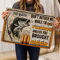 Fishing doormat held indoors showing a large fish, fishing rod, beer bottles, and bold graphic design