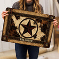 Cowboy doormat held indoors, showing its central western star, cowhide pattern, and ornate rustic border
