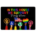 Black LGBT doormat with colorful pride lettering, equality symbols, a flag, earth graphic, and raised fists