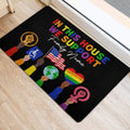 LGBT pride doormat arranged beside a doorway on light wood flooring