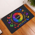 LGBT pride entryway mat displayed by a white door on a wood floor with a rainbow sunflower design