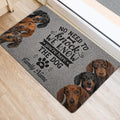 Dachshund door mat placed inside an entryway beside a door, featuring dog portraits and paw art