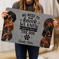 Person holding a dachshund doormat featuring realistic dog portraits, paw art, and a humorous welcome design