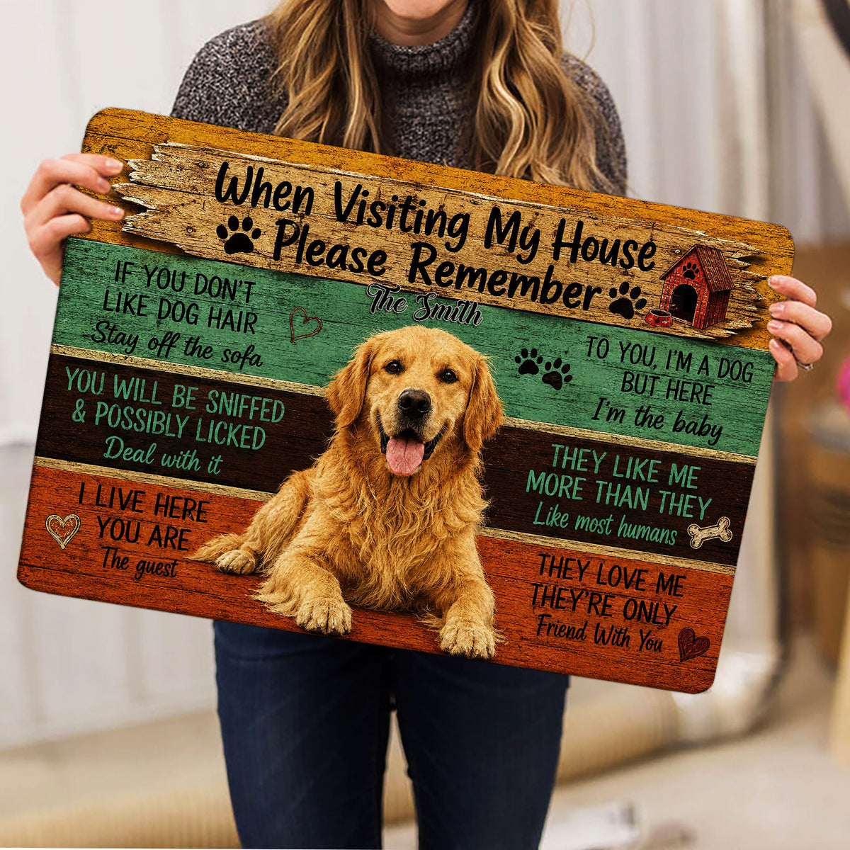 Person holding a Golden Retriever doormat featuring a smiling dog, paw prints, doghouse, and wood-plank design