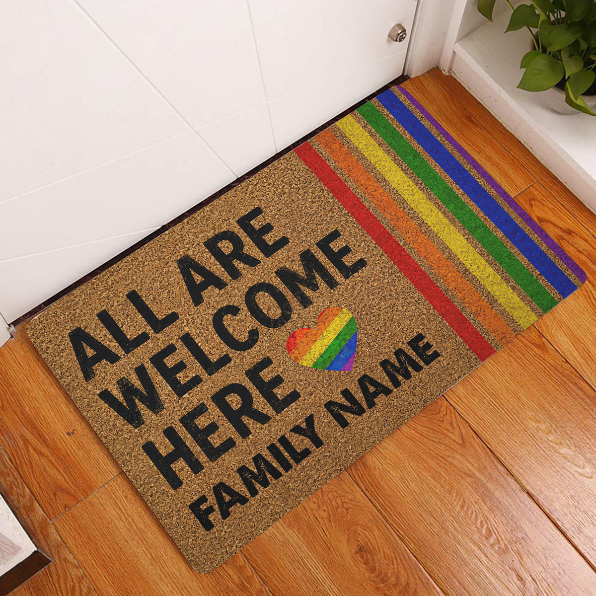 LGBT pride doormat displayed at a home entrance with rainbow stripes and welcoming artwork