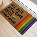 Rainbow LGBT welcome doormat placed by an interior doorway on a light wood floor
