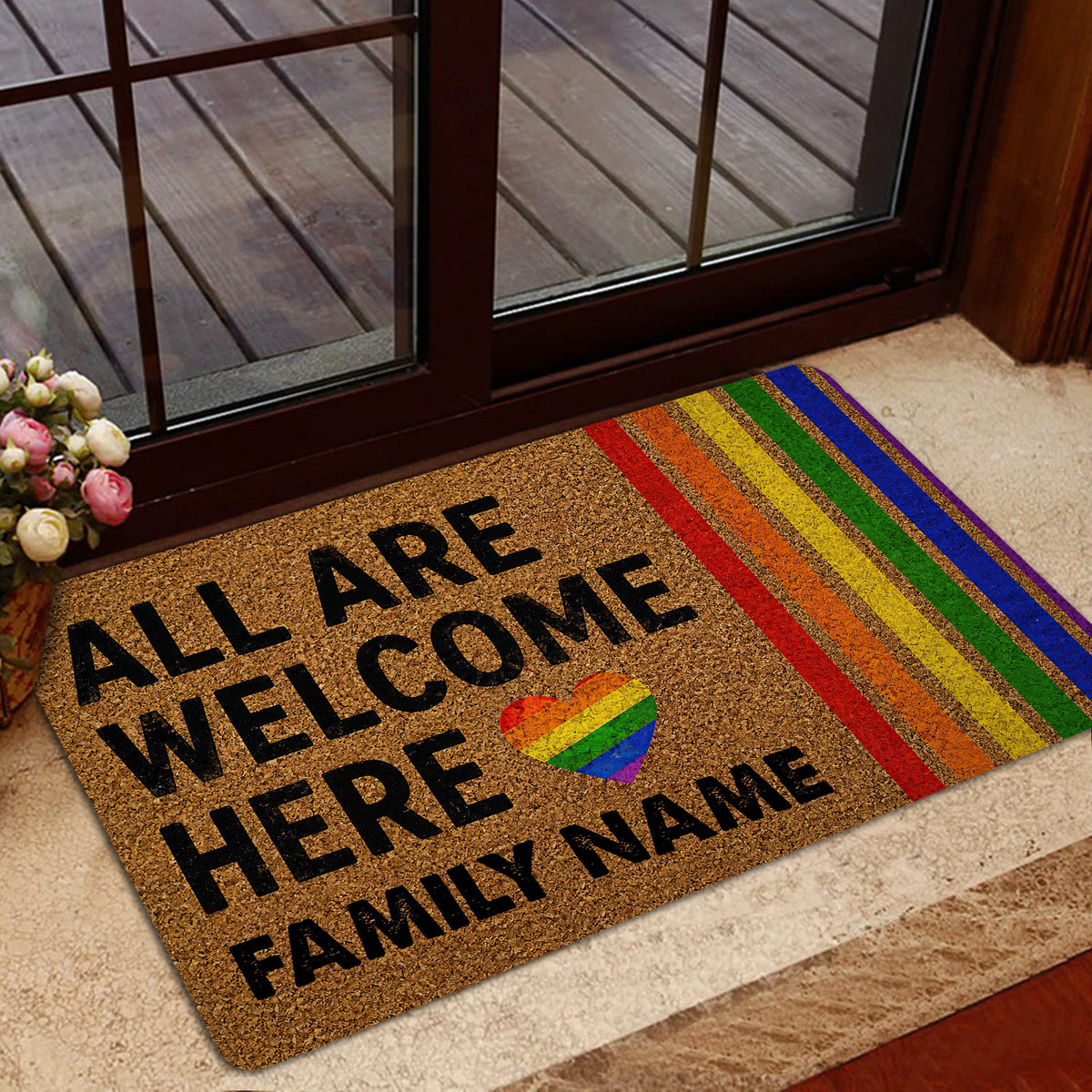 LGBT pride entryway mat with rainbow stripes and welcoming message beside a glass door