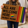 Person holding a colorful LGBT pride doormat with rainbow heart and inclusive welcome design