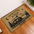 Camping-themed entryway doormat displayed indoors on a wood floor near a white door