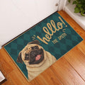 Pug welcome doormat displayed at an indoor entryway on a warm wood floor