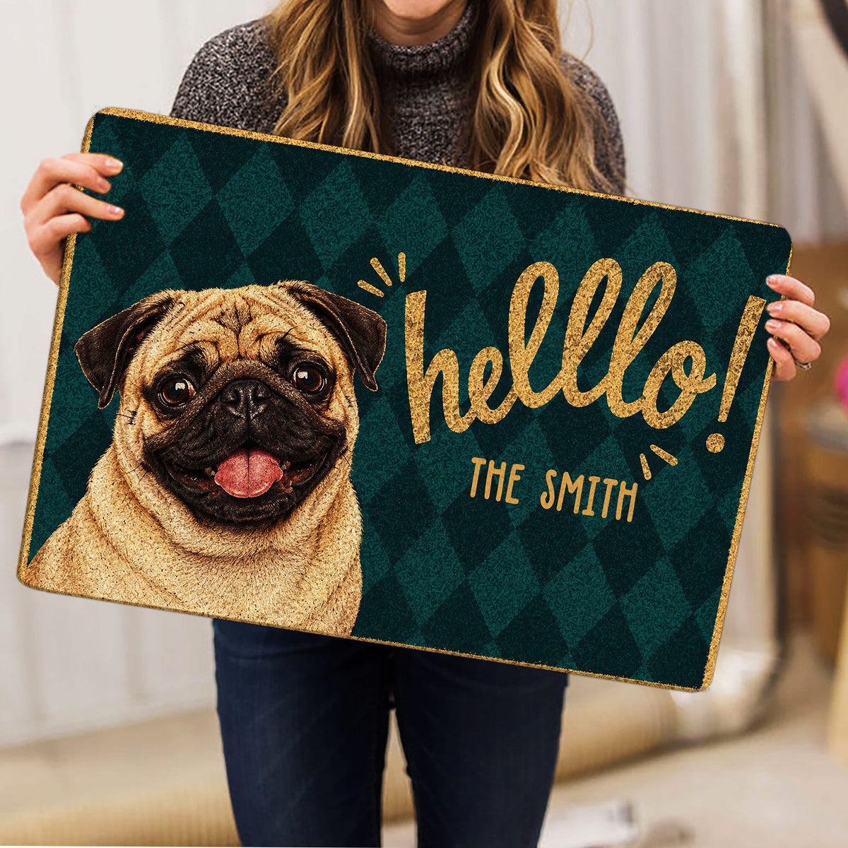 Pug welcome doormat held indoors, showing the full illustrated design and decorative border