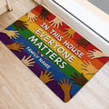 Colorful LGBT entryway rug with rainbow stripes and diverse hand artwork beside a doorway