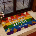 Rainbow LGBT doormat styled inside a home entrance near a glass door and floral arrangement