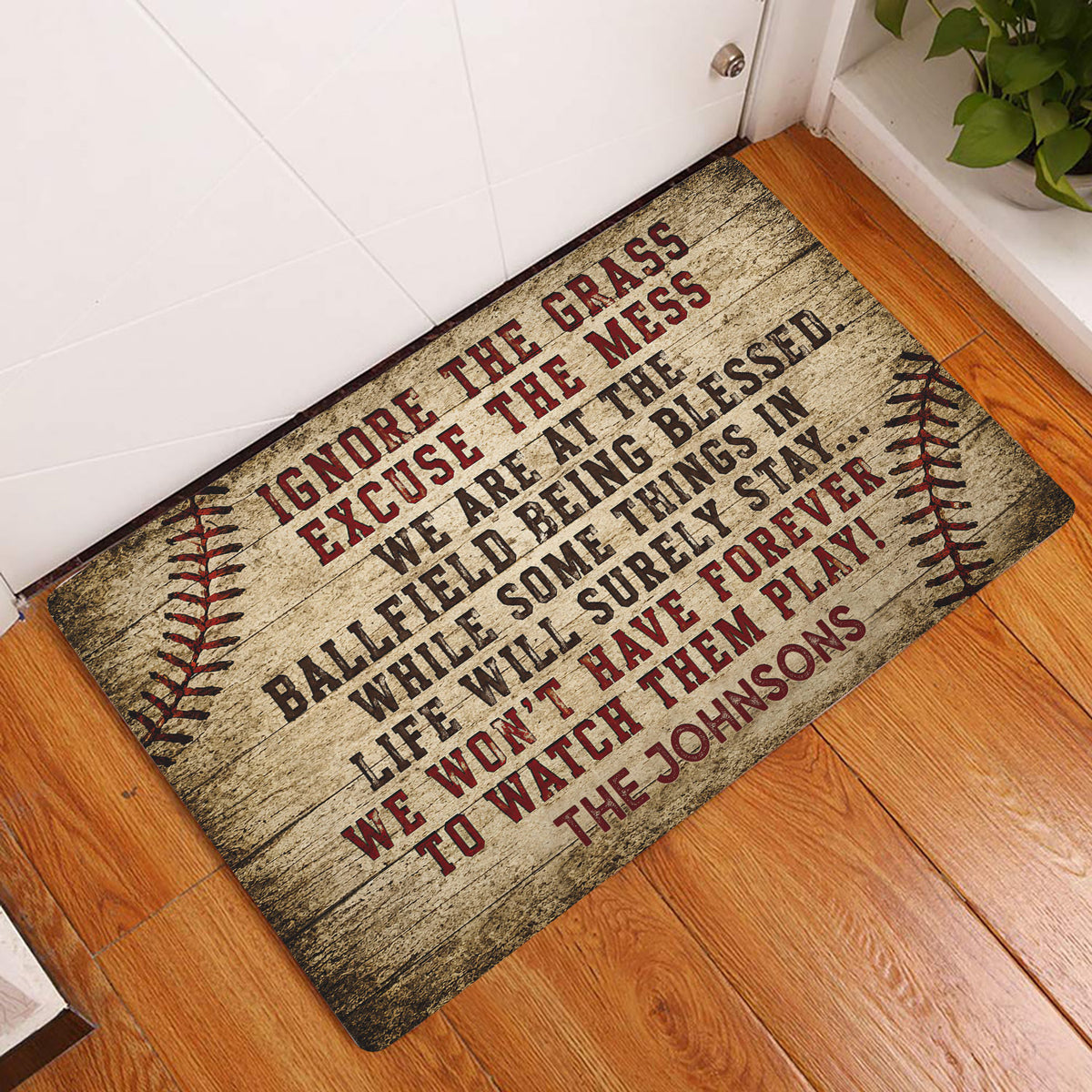 Baseball doormat displayed at an indoor doorway on hardwood flooring with rustic ballfield artwork